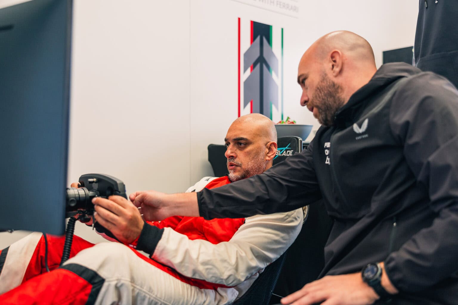 An FF Corse member getting guidance in the simulator